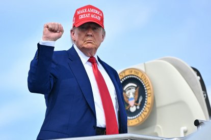US President Donald Trump pumps his fist as he boards Air Force One at Morristown Municipal Airport in Morristown, New Jersey, on June 21, 2025 as he returns to the White House from his golf club in Bedminster, New Jersey. (Photo by Mandel NGAN / AFP)