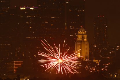 Fuegos artificiales iluminan el cielo con el centro de la ciudad
