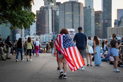 Una persona se envuelve con una bandera de Estados Unidos