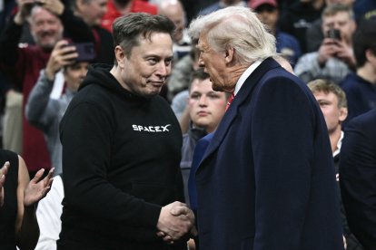 Tesla and SPaceX CEO Elon Musk and US President Donald Trump shake hands as they attend the men's NCAA wrestling competition at the Wells Fargo Center in Philadelphia, Pennsylvania, on March 22, 2025. (Photo by Brendan SMIALOWSKI / AFP) / ALTERNATE CROP