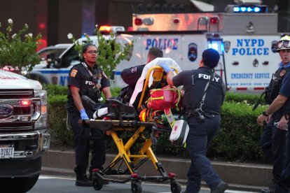 Los bomberos del FDNY trasladan a un oficial de policía en una camilla