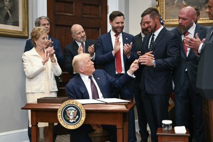 Donald Trump bromea con el golfista Bryson DeChambeau durante la firma