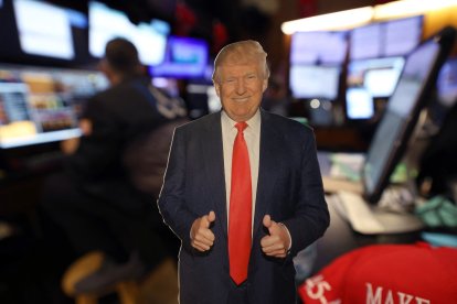 Una silueta recortada del presidente estadounidense Donald Trump se encuentra sobre una mesa mientras los operadores trabajan en la sala de la Bolsa de Nueva York (NYSE) durante la campana de apertura en Nueva York el 11 de julio de 2025.