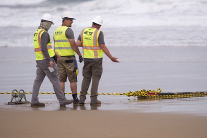 Los operadores conversan mientras instalan un cable submarino de fibra óptica en la playa de Arrietara, cerca del pueblo vasco español de Sopelana, el 13 de junio de 2017. Facebook y Microsoft se han asociado para instalar un gigantesco cable submarino denominado Marea, que se extenderá desde Virginia (Estados Unidos) hasta Bilbao (España), atravesando unos 6600 kilómetros de océano.