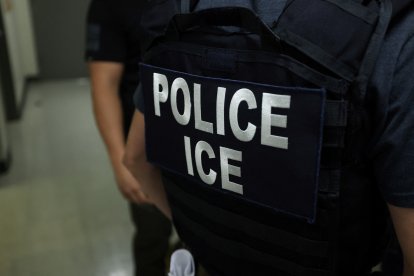 An agent of Immigration and Customs Enforcement (ICE) waits in a hallway outside of a courtroom at New York Federal Plaza Immigration Court inside the Jacob K. Javitz Federal Building in New York on July 17, 2025. US President Donald Trump has made deporting undocumented immigrants a key priority for his second term, after successfully campaigning against an alleged "invasion" by criminals. (Photo by CHARLY TRIBALLEAU / AFP)