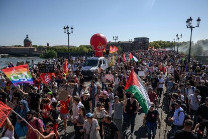 Marcha de personas con banderas y pancartas en Toulouse.