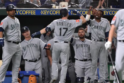 Mitch Haniger es recibido por sus compañeros de equipo.