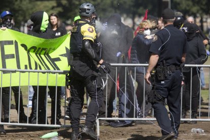Un activista de Antifa rocía a la policía con un spray Silly String y la policía responde con spray pimienta  durante una protesta contra el grupo de The Patriot Prayer Movement, que estaba celebrando una manifestación en el centro de Portland, Oregón, el 10 de septiembre de 2017. Varios cientos de manifestantes  se congregaron en el centro de Portland para oponerse al grupo de extrema derecha.