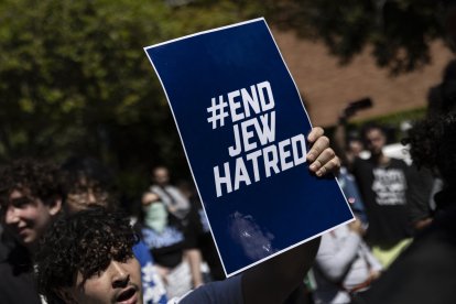 Un manifestante proisraelí sostiene un cartel con el lema «Acabemos con el odio hacia los judíos» en el campus de la Universidad de California en Los Ángeles (UCLA), en Los Ángeles, el 28 de abril de 2024. Las protestas pro palestinas se extendieron a más campus universitarios de Estados Unidos el 25 de abril de 2024, mientras las autoridades parecían estar agotando su paciencia y la policía comenzaba a reprimirlas con fuerza. Los agentes antidisturbios utilizaron irritantes químicos y pistolas eléctricas en una universidad, mientras los administradores de algunas de las instituciones más prestigiosas del país luchaban por impedir que las ocupaciones se afianzaran.