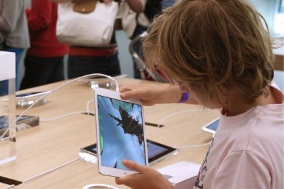 Un menor juega con un iPad en una tienda de Apple