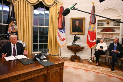 La jefa de gabinete de la Casa Blanca, Susie Wiles, y el jefe de gabinete adjunto de la Casa Blanca, Dan Scavino, observan al presidente estadounidense, Donald Trump, mientras habla con los periodistas en el Despacho Oval de la Casa Blanca en Washington, DC, el 20 de enero de 2025.