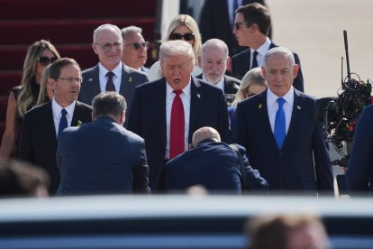 El presidente Donald Trump, en el centro, camina con el primer ministro de Israel, Benjamin Netanyahu, a su llegada al aeropuerto Ben Gurion, cerca de Tel Aviv, Israel, el lunes 13 de octubre de 2025.