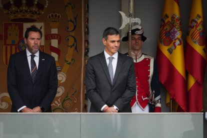Pedro Sánchez (centro) y el ministro Oscar Puente (izq.) durante el desfile de la Fiesta Nacional