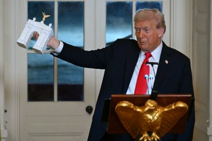 El presidente estadounidense Donald Trump sostiene una maqueta del proyecto del "Arco de la Independencia".