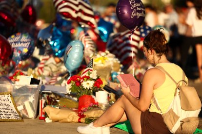 Una joven lee una biblia en el memorial dedicado a Charlie Kirk