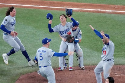 El lanzador de los Dodgers de Los Ángeles, Yoshinobu Yamamoto (18), celebra con sus compañeros de equipo tras derrotar a los Blue Jays de Toronto al final de la undécima entrada del séptimo partido de la Serie Mundial de béisbol de la MLB, disputado en Toronto el domingo 2 de noviembre de 2025.
