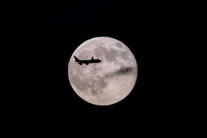 Un avión Boeing 747 cruza por delante de la super luna, Alaska