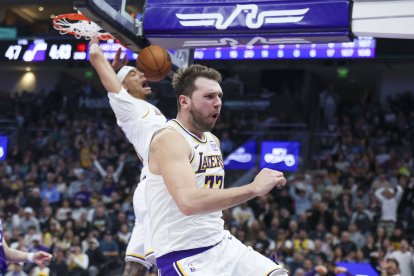El escolta de Los Angeles Lakers, Luka Doncic (77), reacciona ante un mate del pívot Jaxson Hayes (11) contra los Utah Jazz durante el segundo cuarto en el Delta Center.