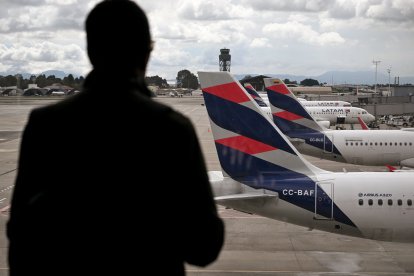 Un pasajero venezolano mira un avión de LATAM (Archivo)