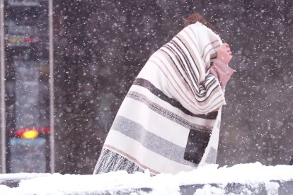 Un peatón camina durante una tormenta de nieve-Imagen de Archivo