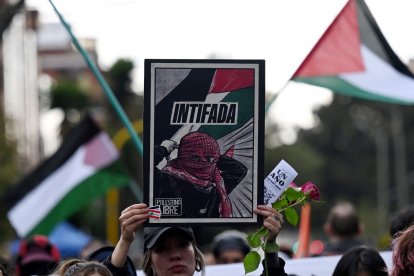 A demonstrator holds a banner that reads 'Intifada'