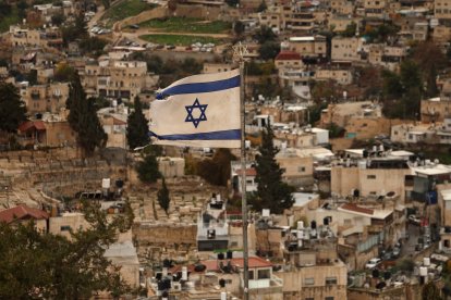 An Israeli flag flutters in the wind over the Arab East Jerusalem neighbourhood of Silwan