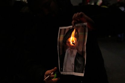 Un manifestante quema una imagen del ayatolá Ali Jamenei