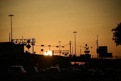 El sol sale mientras los vehículos viajan durante la hora pico de la mañana en Houston, Texas, el 8 de abril de 2025.