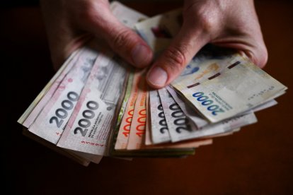 (Archivo) Una manos sostiene billetes argentinos