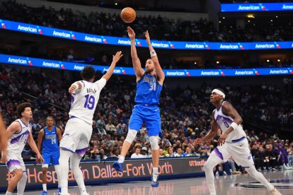 El escolta de los Dallas Mavericks, Klay Thompson (31), lanza contra el escolta de los Utah Jazz, Ace Bailey (19), y el alero Taylor Hendricks (0) durante la segunda mitad de un partido de baloncesto de la NBA en Dallas, el jueves 15 de enero de 2026.