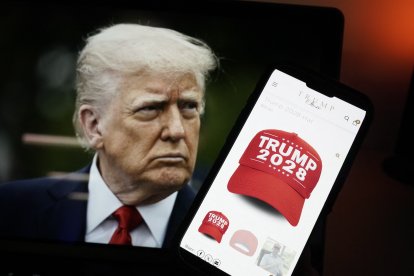 Esta fotoilustración, tomada el 24 de abril de 2025 en Washington, D.C., muestra una imagen del presidente estadounidense Donald Trump junto a un teléfono inteligente con una gorra roja con la leyenda 