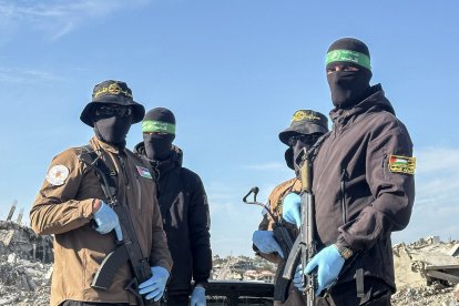 Hombres armados de Hamás y la Yihad Islámica en Palestina entregan al personal de la Cruz Roja un cuerpo que recuperaron de Beit Lahia antes de entregárselo a Israel para determinar si pertenece a uno de los rehenes, norte de la Franja de Gaza, 3 de diciembre de 2025