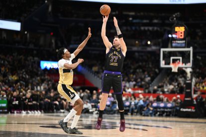 El base de Los Angeles Lakers, Luka Doncic (77), lanza contra el base de los Washington Wizards, Bilal Coulibaly (0), durante la segunda mitad de un partido de baloncesto de la NBA, el viernes 30 de enero de 2026, en Washington.