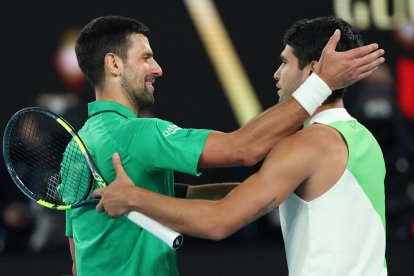 El serbio Novak Djokovic (izquierda) felicita al español Carlos Alcaraz por su victoria tras la final masculina individual del decimoquinto día del torneo de tenis Abierto de Australia, celebrado en Melbourne el 1 de febrero de 2026.