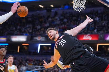 El pívot de los Houston Rockets, Alperen Sengun (28), recibe una falta por detrás del alero de los Indiana Pacers, Bennedict Mathurin (00), durante la segunda mitad de un partido de baloncesto de la NBA en Indianápolis.