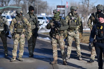 Federal law enforcement agents confront anti-US Immigration and Customs Enforcement (ICE) protesters outside the Bishop Henry Whipple Federal Building during a demonstration over the fatal shooting of Renee Good by an ICE agent in Minneapolis, Minnesota, on January 9, 2026. A US Immigration and Customs Enforcement (ICE) agent shot and killed an American woman on the streets of Minneapolis January 7, leading to huge protests and outrage from local leaders who rejected White House claims she was a domestic terrorist. The woman, identified in local media as 37-year-old Renee Nicole Good, was hit at point blank range as she apparently tried to drive away from agents who were crowding around her car, which they said was blocking their way. (Photo by Octavio JONES / AFP)