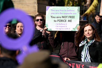 Personas sostienen pancartas y banderas en una manifestación de Women Will Speak en Melbourne el 16 de agosto de 2025, lamentando la erosión de los derechos de las mujeres ante las reivindicaciones de identidad transgénero.