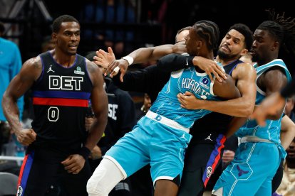 El alero de los Charlotte Hornets, Moussa Diabate, delante a la derecha, es retenido mientras se pelea con el pívot de los Detroit Pistons, Jalen Duren (0), durante la segunda mitad de un partido de baloncesto de la NBA en Charlotte, Carolina del Norte, el lunes 9 de febrero de 2026.