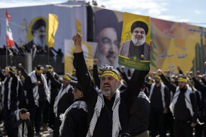 Manifestantes, rodeados de carteles con imágenes de los exlíderes de Hezbolá, Hassan Nasrallah y Hashem Safieddine, corearon consignas durante su procesión fúnebre en el lugar de entierro de Nasrallah, en los suburbios del sur de Beirut, Líbano, el domingo 23 de febrero de 2025. (Foto AP/Bilal Hussein)