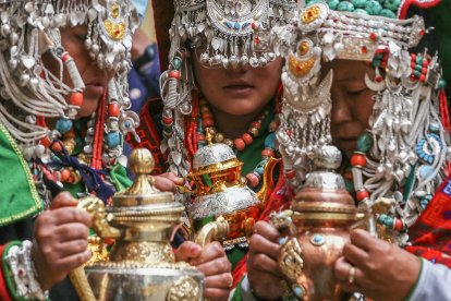 Personas vestidas con atuendos tradicionales asisten a la ceremonia de oración del líder espiritual tibetano, el Dalai Lama.