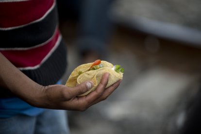 Un inmigrante latino sostiene un taco mexicano (Archivo)