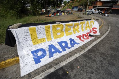 Una pancarta que dice "Libertad para todos" se exhibe frente a la prisión El Rodeo I en Guatire