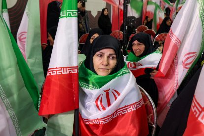 Mujeres con banderas iraníes de luto por las víctimas del terrorismo fallecidas en las protestas en Irán
