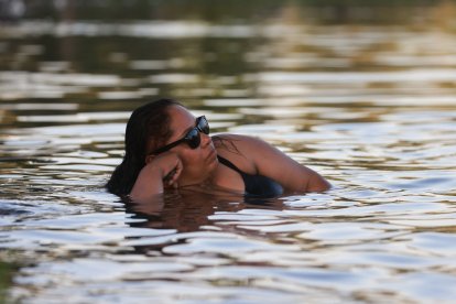 Una mujer adulta se refresca en un lago (Archivo)