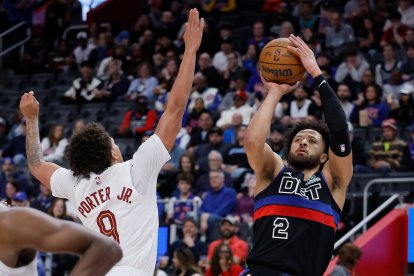 El base de los Detroit Pistons, Cade Cunningham (2), lanza un tiro en suspensión contra el base de los Cleveland Cavaliers, Craig Porter Jr. (9), durante la primera mitad de un partido de baloncesto de la NBA el viernes 27 de febrero de 2026 en Detroit.