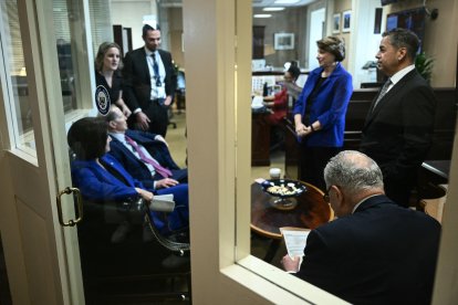 US Senate Minority Leader Chuck Schumer (lower R), Democrat from New York, huddles with Senate Democrats before a news conference