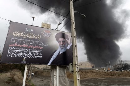 Un retrato del líder supremo iraní, el ayatolá Ali Jamenei, se exhibe frente al depósito de petróleo de Shahran, que fue blanco de ataques estadounidenses-israelíes, en el octavo día de la guerra en el oeste de Teherán, Irán, el domingo 8 de marzo de 2026