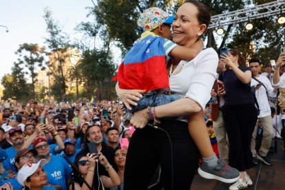 a María Corina Machado abraza a un niño durante un encuentro con miembros de la comunidad venezolana en Chile