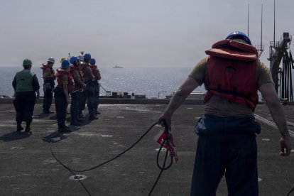 Marineros de la Armada de los Estados Unidos se preparan para tirar de una cuerda durante un reabastecimiento en el mar en la cubierta de vuelo del portaaviones clase Nimitz USS Abraham Lincoln (CVN 72) durante la Operación Epic Fury, el 10 de marzo de 2026. (Foto de la Armada de los Estados Unidos)