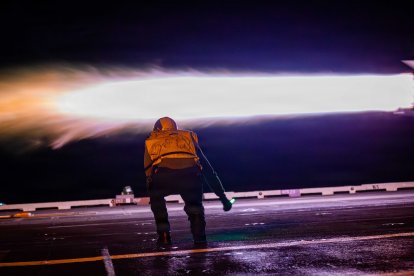 Un marinero estadounidense da la señal de despegue de un avión F/A-18F Super Hornet, adscrito al Escuadrón de Cazas de Ataque 213, en la cubierta de vuelo del portaaviones más grande del mundo, el USS Gerald R. Ford (CVN 78), durante la Operación Epic Fury, el 15 de marzo de 2026. (Foto de la Armada de los Estados Unidos)